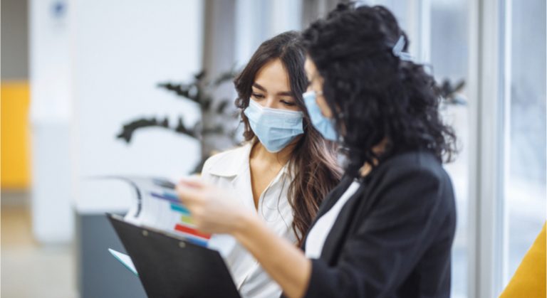 trabalhadoras usando máscaras no escritório