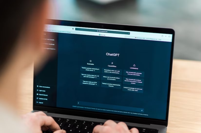 Mulher olhando para macbook com tela inicial do chat gpt