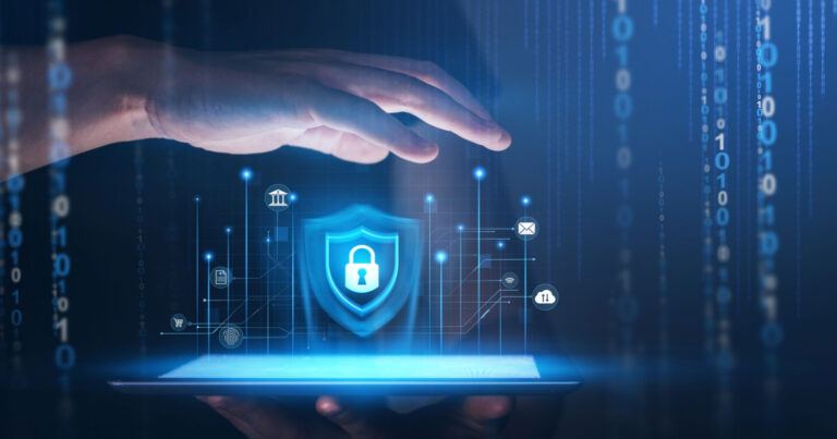 Imagem conceitual de cibersegurança, mostrando uma mão protegendo um escudo com ícone de cadeado no centro, representando proteção digital. O fundo apresenta elementos tecnológicos, como números binários e ícones de conectividade, destacando segurança em ambientes digitais (ciberataques, segurança, proteção de dados, inteligência artificial, segurança cibernética)