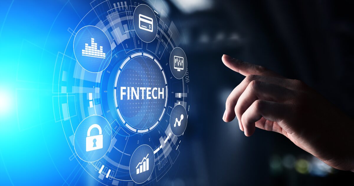 Interface digital futurista com o termo "fintech" destacado no centro, cercado por ícones relacionados a tecnologia financeira, como gráficos, cadeado, cartão de crédito e transações. Uma mão está apontando para a tela, simbolizando interação com a tecnologia. O fundo é azul e escuro, reforçando a atmosfera tecnológica e moderna. (impacto, ia, fintechs, growth)