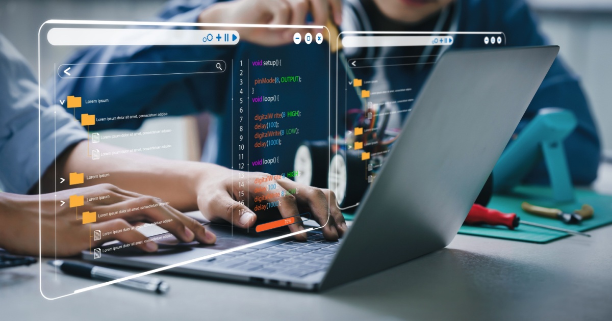 Dois estudantes trabalham em um projeto de tecnologia, com um laptop exibindo códigos de programação em uma interface holográfica interativa, destacando aprendizado de software e desenvolvimento técnico (steam, tecnologia, software, estudantes, alunos, Udemy, Alura, IA generativa)