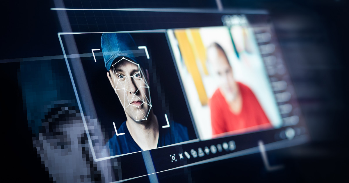 Tela de computador exibindo um sistema de reconhecimento facial analisando o rosto de um homem de boné, com um padrão geométrico sobreposto à sua face. Ao lado, uma imagem de outra pessoa, sugerindo um possível caso de deepfake ou identificação digital. A cena representa tecnologia de inteligência artificial e segurança digital (identificação, deepfake, fake news, inteligência artificial, ia, notícias falsas, riscos, cibersegurança, segurança, vídeos falsos, bytedance)