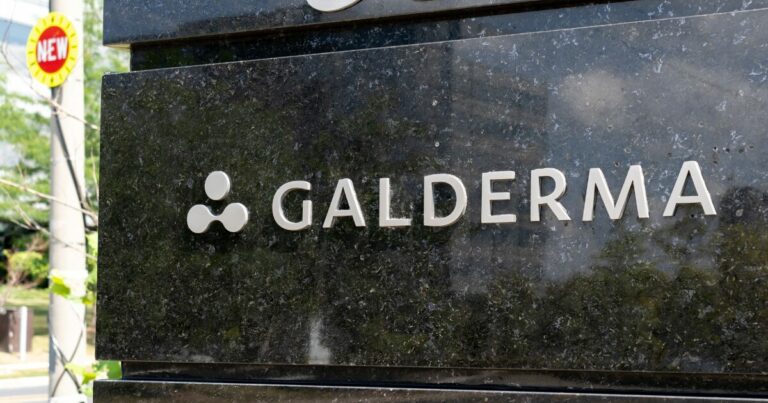 Placa de entrada da empresa Galderma, com o logotipo e nome da empresa em letras prateadas em um fundo de mármore escuro. A imagem ilustra a identidade visual da Galderma, empresa onde Eduardo Kondo foi recentemente nomeado como Global IT Head - Consumer Experience, assumindo a responsabilidade por estratégias tecnológicas voltadas à experiência do consumidor.