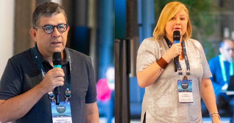 Na imagem, vemos dois palestrantes segurando microfones e usando crachás do evento IT Forum. À esquerda, um homem de óculos e camiseta preta, identificado como Wanderley Schmidt Campos, fala ao público sobre cultura data-driven. À direita, uma mulher loira de camiseta cinza e pulseira marrom no braço esquerdo, identificada como Lyzbeth Chromekold, também discursa. Ambos estão em ambientes internos, com um fundo levemente desfocado, o que indica um evento corporativo ou conferência.