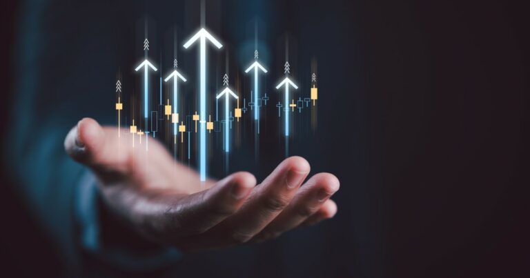 Mão estendida segurando gráficos ascendentes com setas brilhantes, simbolizando crescimento, progresso e sucesso em estratégias organizacionais.
