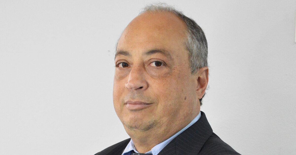 Foto de Jefferson Penteado, CEO e fundador da BluePex, olhando levemente para a câmera. Ele veste um terno escuro com camisa azul clara e gravata, posando contra um fundo branco.