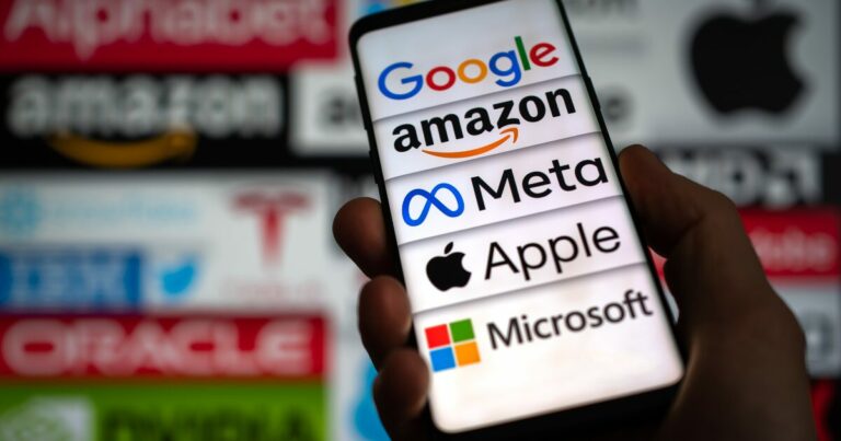 Imagem de um smartphone exibindo os logotipos de grandes empresas de tecnologia, como Google, Amazon, Meta, Apple e Microsoft, em destaque na tela. Ao fundo, desfocado, estão os logos. (big techs) Nasdaq, antitruste