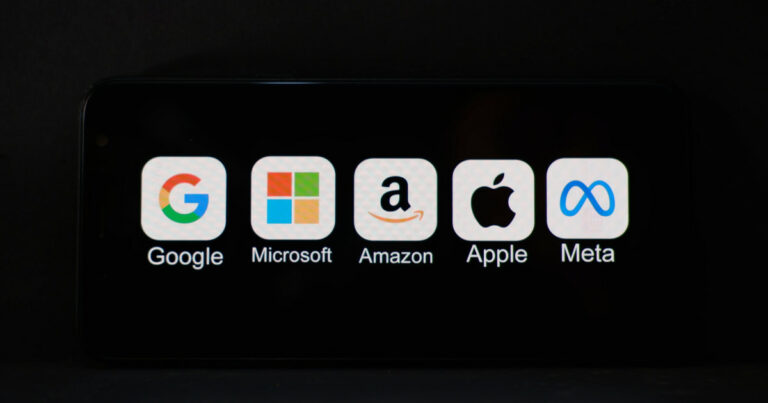"Imagem mostrando ícones e nomes das principais empresas de tecnologia: Google, Microsoft, Amazon, Apple e Meta, exibidos em uma tela preta. Representação das chamadas 'Big Techs'