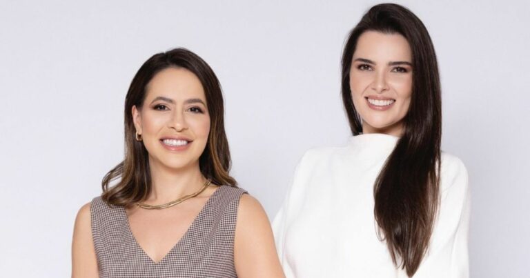 Imagem das fundadoras da Hera Build. À esquerda, Suzana Oliveira, CRO, vestindo roupa em tons neutros e colar dourado, sorrindo para a câmera. À direita, Bárbara Vallim, CEO, vestindo blusa branca, também sorrindo. Ambas transmitem confiança e profissionalismo.