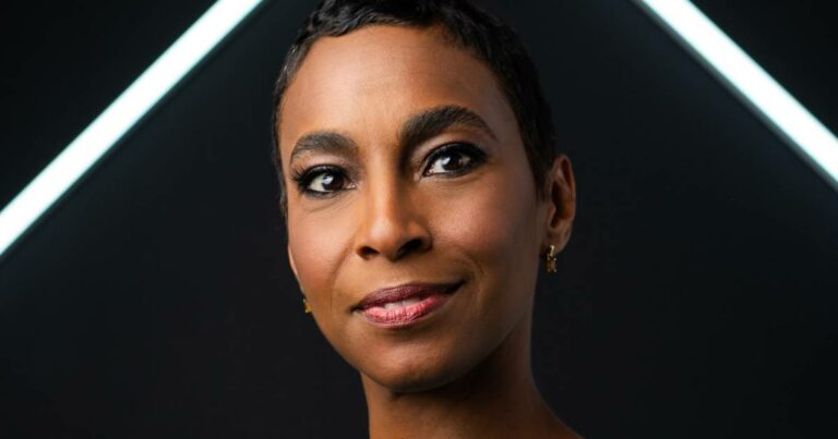 Dilma Sousa Campos, CEO da Nova Praia e CSO da B&Partners.co, em close-up, com expressão confiante e leve sorriso, usando brincos pequenos dourados. O fundo é escuro com linhas diagonais de luz branca, criando um visual moderno e sofisticado.