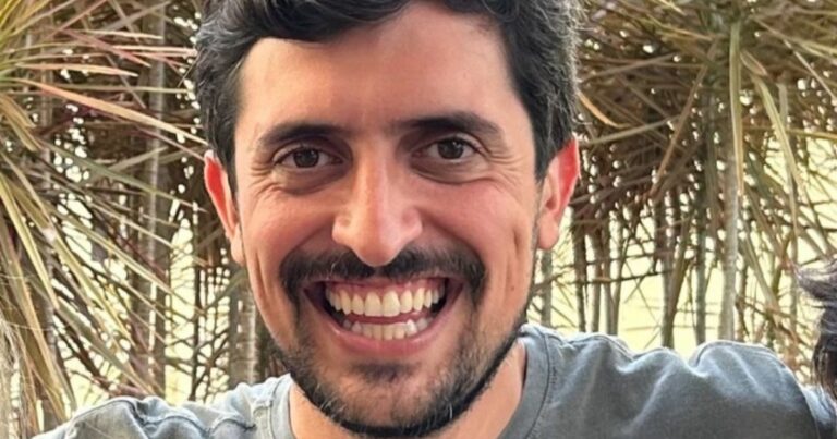 Homem branco sorrindo para a foto