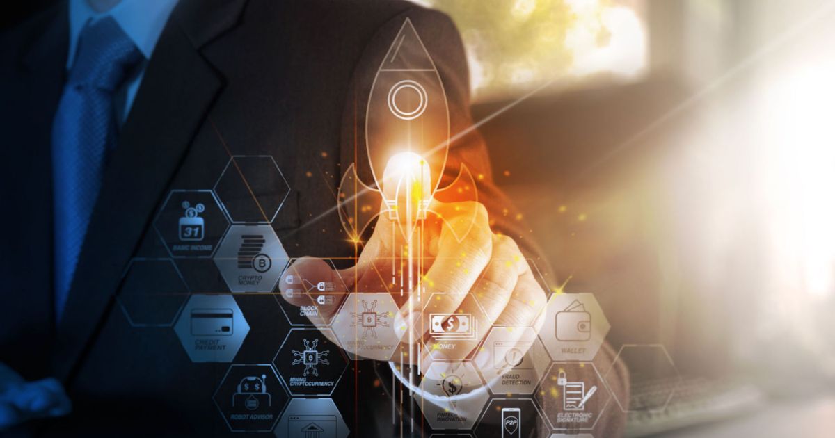 A imagem mostra um homem de terno tocando uma interface digital holográfica com elementos gráficos relacionados a tecnologia e finanças. No centro, um ícone de foguete iluminado simboliza o lançamento de um novo projeto ou startup. Ao redor, hexágonos exibem ícones e textos relacionados a blockchain, pagamentos digitais, criptomoedas e assinaturas eletrônicas. A cena transmite uma sensação de inovação, investimentos em tecnologia e crescimento acelerado, temas comuns no universo de venture capital (venture capital, vc, startups, aportes, investimentos, equity, CloudWalk, assin)
