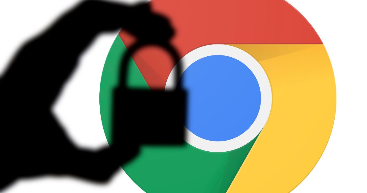 Imagem com o logotipo do navegador Google Chrome ao fundo e a silhueta de uma mão segurando um cadeado em destaque no primeiro plano. A composição transmite a ideia de segurança, privacidade e proteção de dados na navegação online.