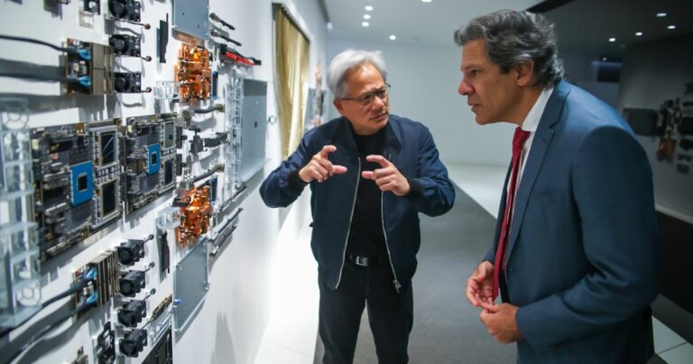 Dois homens observam e discutem uma parede expositiva com várias peças de hardware e componentes electrónicos, num ambiente moderno e iluminado.
