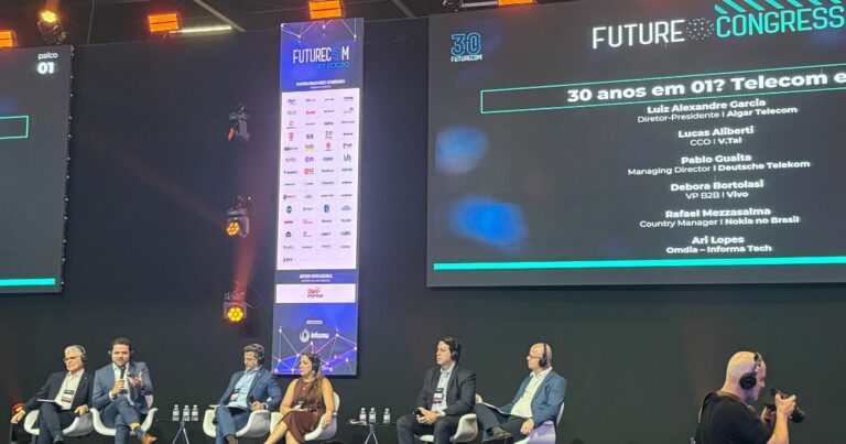 A imagem retrata um painel de discussão durante o evento Futurecom Congress. Seis pessoas estão sentadas no palco, cada uma com um microfone, participando da conversa. Acima deles, uma tela exibe o título da sessão: "30 anos em 01? Telecom e...", junto aos nomes e cargos dos painelistas: Luiz Alexandre Garcia, Diretor-Presidente – Algar Telecom Lucas Alberti, CCO – V.tal Pablo Guaita, Managing Director – Deutsche Telekom Debora Tortolai, VP B2B – Vivo Rafael Mezzasalma, Country Manager – Nokia no Brasil Ari Lopes – Omdia / Informa Tech O fundo inclui banners com logotipos de patrocinadores e a identidade visual do evento. O ambiente é formal e voltado para discussões sobre o setor de telecomunicações.