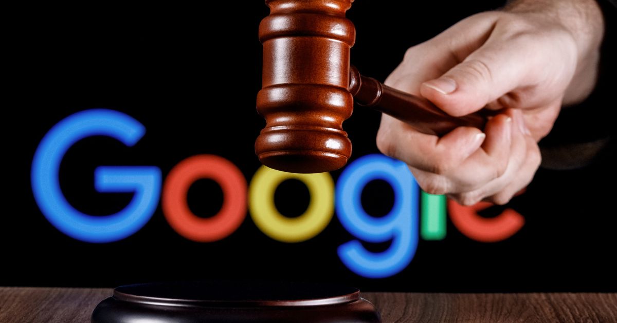Uma mão segura um martelo de juiz de madeira, posicionado acima de uma base de som. Ao fundo, aparece o logotipo do Google com suas cores e fonte características, sugerindo um contexto relacionado a decisões judiciais ou legais envolvendo a empresa.