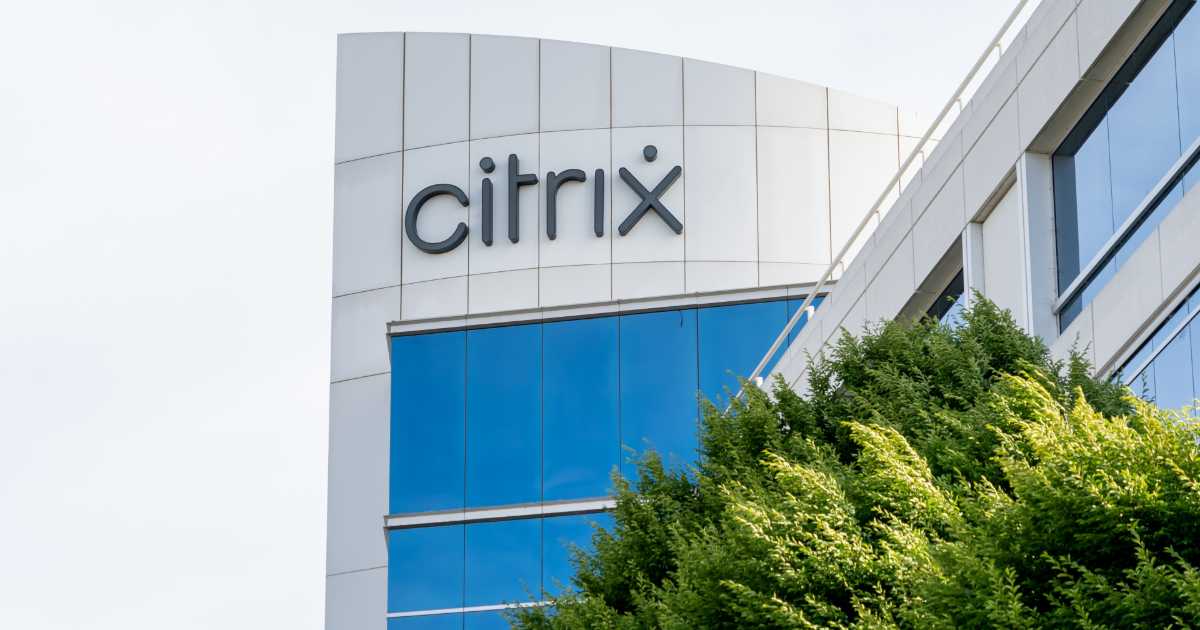 Fachada de um prédio corporativo moderno com o logo “Citrix” em destaque na parte superior, mostrando paredes brancas curvas, janelas de vidro azul refletivo e árvores verdes em primeiro plano (licenciamento)