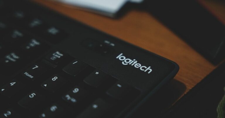 A imagem mostra um teclado da marca Logitech, posicionado sobre uma superfície de madeira, sugerindo um ambiente de trabalho ou escritório.