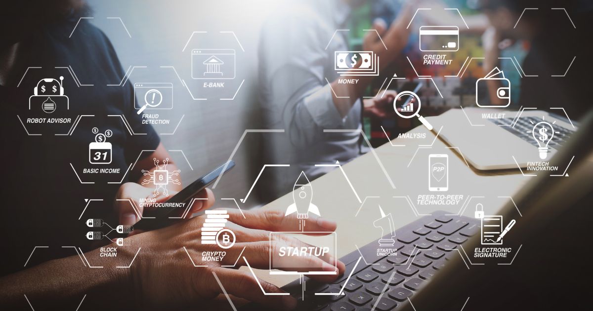 A imagem mostra um ambiente de trabalho moderno, com pessoas utilizando dispositivos digitais. É uma cena que remete a tecnologia financeira (fintech), startups e inovação digital. (Flatpay)