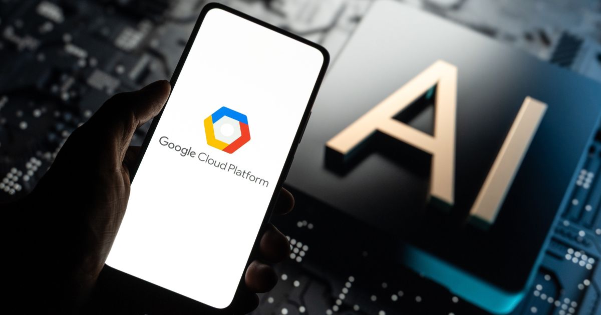 A imagem apresenta um cenário tecnológico com dois elementos principais: Primeiro plano: Um smartphone exibindo a tela com o logotipo e o texto Google Cloud Platform. O design é limpo, com fundo branco e o ícone colorido característico da plataforma. Segundo plano: Um grande bloco com as letras AI em destaque, sobre uma superfície que lembra uma placa de circuito eletrônico, reforçando a ideia de inteligência artificial e infraestrutura tecnológica. Cores e atmosfera: Tons escuros predominam no fundo, contrastando com o brilho da tela do celular, criando uma estética moderna e inovadora. Essa imagem transmite conexão entre computação em nuvem e inteligência artificial, ideal para conteúdos sobre tecnologia, inovação, soluções em nuvem e transformação digital.