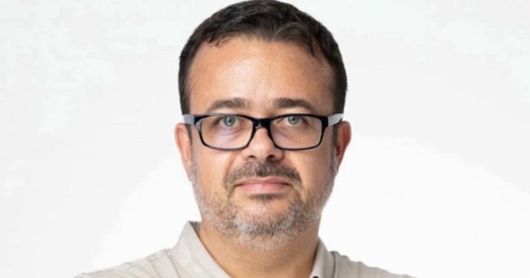 A imagem mostra uma pessoa em plano médio, com fundo branco e iluminação uniforme, criando um visual limpo e profissional. Aqui estão os principais detalhes: Vestimenta: Camisa clara, com gola aberta, transmitindo um estilo casual elegante. Composição: A imagem está centralizada, com foco no tronco e parte superior, sugerindo um retrato corporativo ou institucional. Atmosfera: Simples e neutra, ideal para uso em perfis profissionais, apresentações ou materiais de comunicação. (Compass e Raízen)