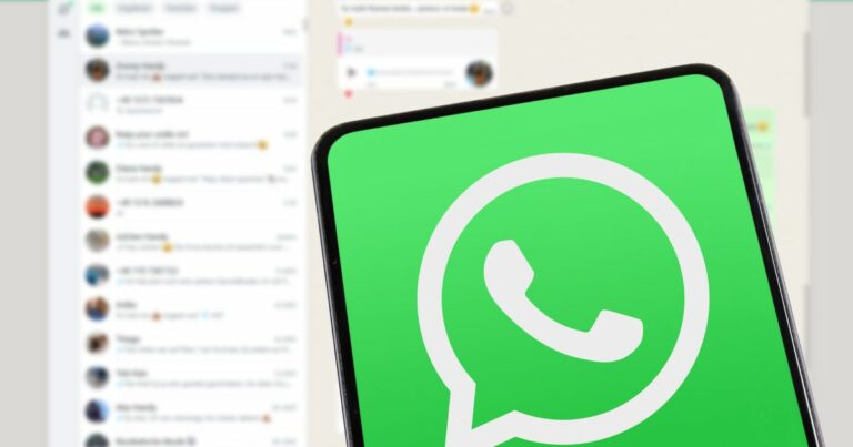 A imagem mostra um smartphone com a tela exibindo o ícone do WhatsApp em destaque, sobre um fundo que parece ser a interface do aplicativo aberta em um computador ou versão web. Detalhes principais: Primeiro plano: Ícone do WhatsApp em verde com o símbolo branco característico (balão de conversa com telefone). O enquadramento foca no dispositivo, ocupando a maior parte da imagem. Plano de fundo: Interface do WhatsApp Web ou Desktop, com lista de conversas visível à esquerda e uma conversa aberta à direita. Elementos como nomes, mensagens e emojis aparecem desfocados, mantendo a privacidade. Cores e iluminação: Predominância de tons verdes e brancos, reforçando a identidade visual do WhatsApp. Iluminação clara e uniforme, criando uma composição limpa e moderna. Essa imagem transmite comunicação digital, conectividade e integração entre dispositivos móveis e desktop.