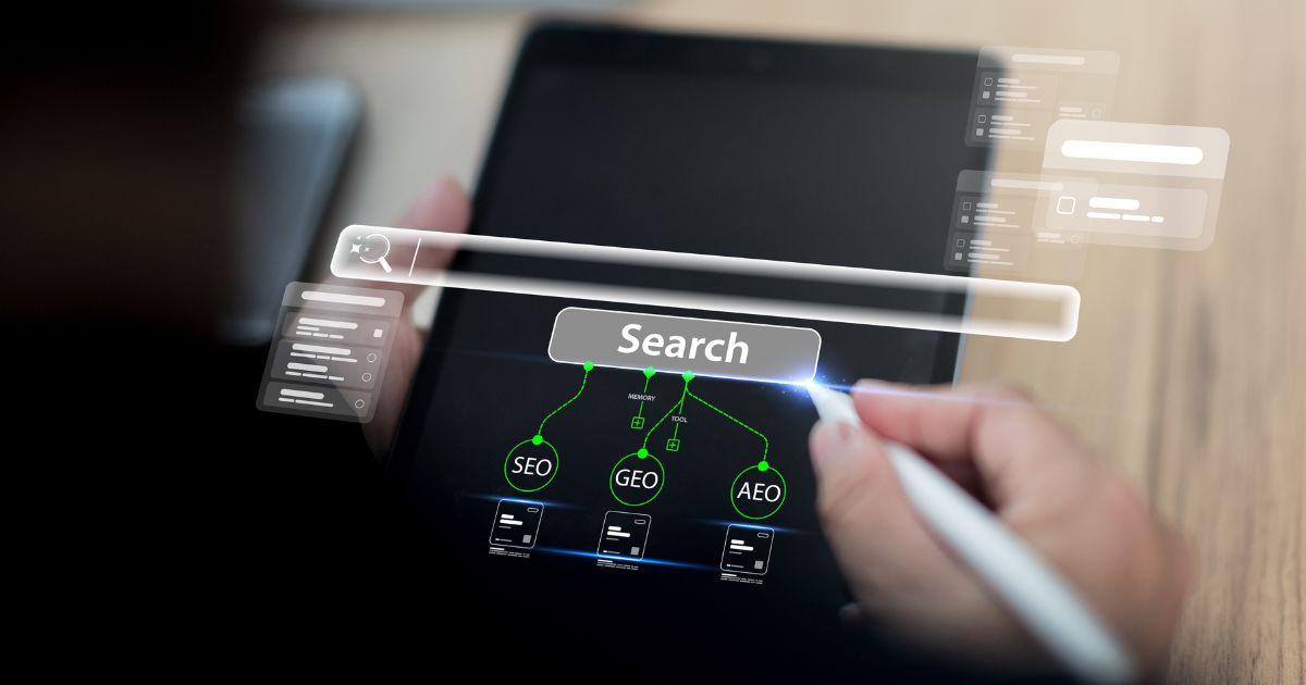 Uma pessoa utiliza uma caneta digital para interagir com a tela de um tablet que exibe uma interface futurista de busca. Um grande campo com a palavra “Search” aparece no centro, acompanhado de elementos gráficos luminosos em verde que representam conexões entre termos como SEO, GEO e AEO. Ícones e janelas flutuantes ao redor da tela sugerem um ambiente de pesquisa avançada, otimização digital ou análise de dados. (LLM)