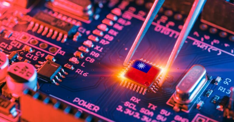 Uma placa-mãe eletrônica é mostrada em close, com destaque para um microchip vermelho que exibe o desenho de um sol estilizado em branco. Um par de pinças metálicas segura cuidadosamente o chip enquanto ele brilha com um efeito de luz intensa, sugerindo instalação ou remoção. A placa possui diversos componentes, como capacitores, resistores e trilhas azuis iluminadas por tons vibrantes de rosa e laranja, criando um visual tecnológico e dinâmico.